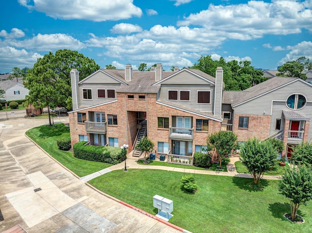 2023 Gentryside Dr Unit 508, Houston, TX 77077 - exterior space with brick siding, a front yard, a chimney, and a balcony