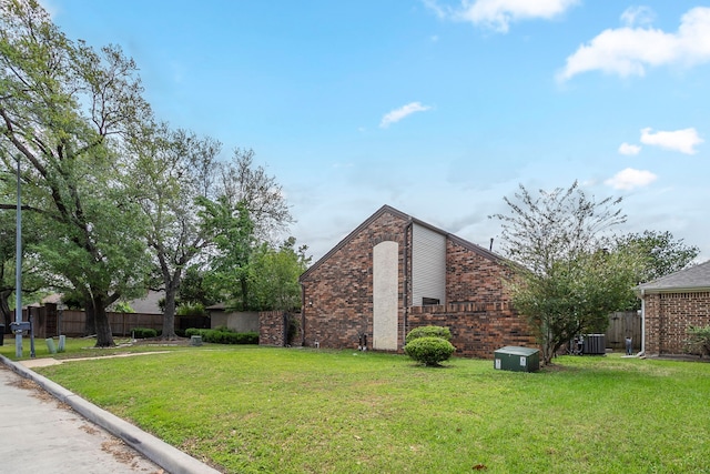 5893 Southern Hills Dr, Houston, TX 77069 - view of side of home featuring fence, a lawn, brick siding, and central AC unit