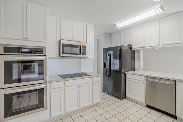 5893 Southern Hills Dr, Houston, TX 77069 - kitchen with a textured ceiling, white cabinetry, black appliances, light countertops, and light tile patterned floors