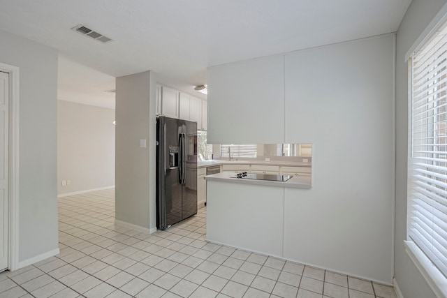 5893 Southern Hills Dr, Houston, TX 77069 - kitchen with white cabinets, a peninsula, visible vents, light countertops, and black appliances