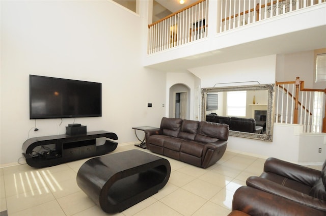 2631 Plantation Hollow Ct, Missouri City, TX 77459 - tiled living room with a towering ceiling, baseboards, and arched walkways