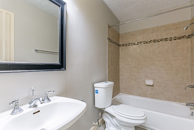 full bathroom featuring a sink, a textured ceiling,  shower combination, and toilet