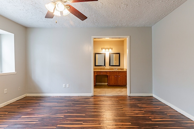 unfurnished bedroom with baseboards, wood finished floors, and a textured ceiling