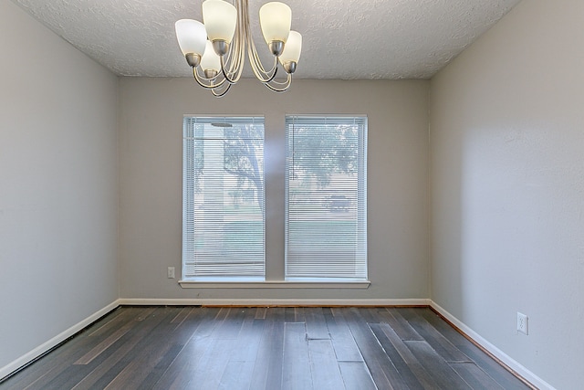 interior space with baseboards, wood finished floors, an inviting chandelier, and a textured ceiling