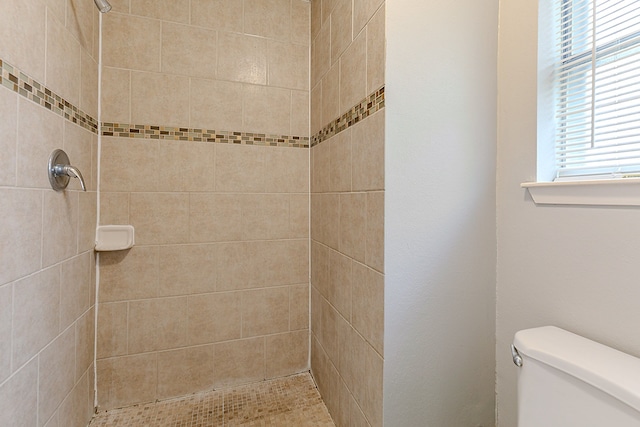 full bath featuring toilet and a tile shower