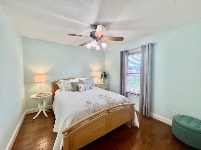 bedroom with dark wood-style flooring, a textured ceiling, baseboards, and ceiling fan