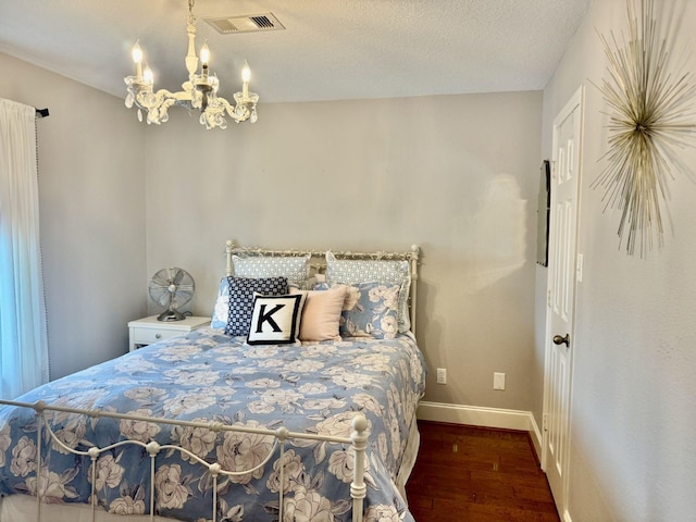bedroom with wood finished floors, a chandelier, and baseboards