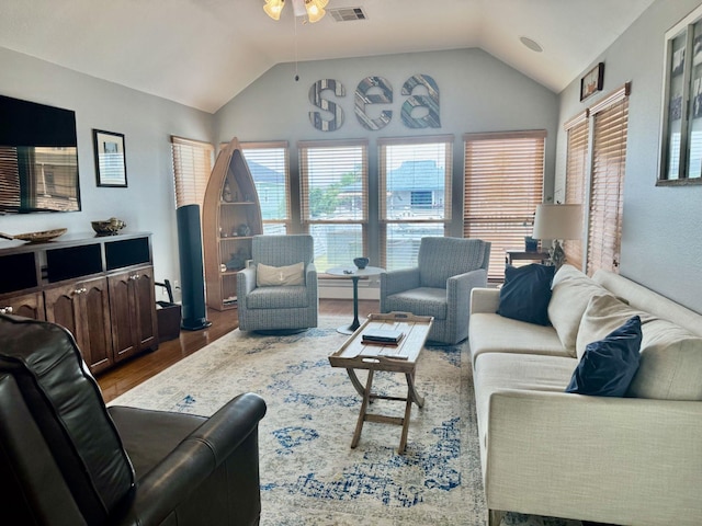 living room featuring lofted ceiling, a ceiling fan, and wood finished floors