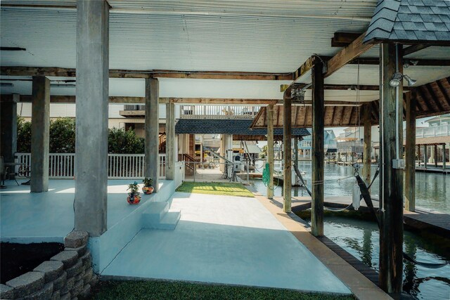 view of patio / terrace with boat lift, a dock, and a water view