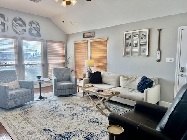 living area with ceiling fan, wood finished floors, and vaulted ceiling