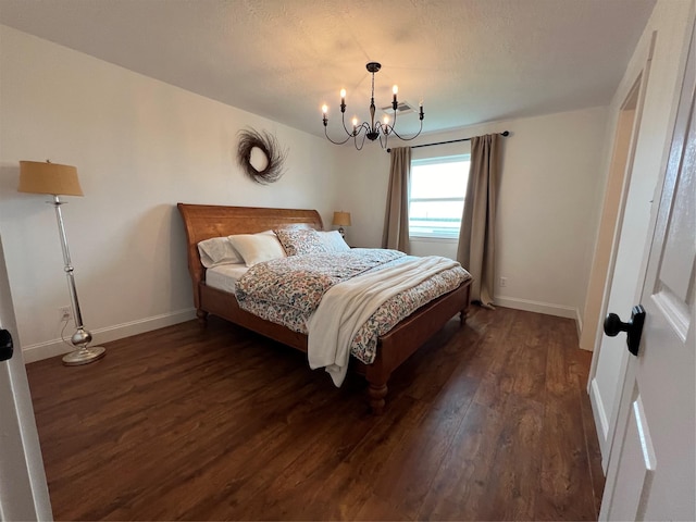 bedroom featuring dark wood-type flooring, baseboards, and an inviting chandelier