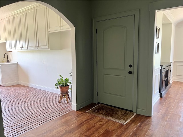 entryway featuring wood finished floors and arched walkways