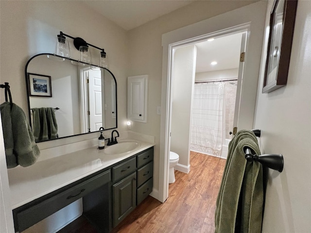 bathroom with toilet, recessed lighting, wood finished floors, curtained shower, and vanity