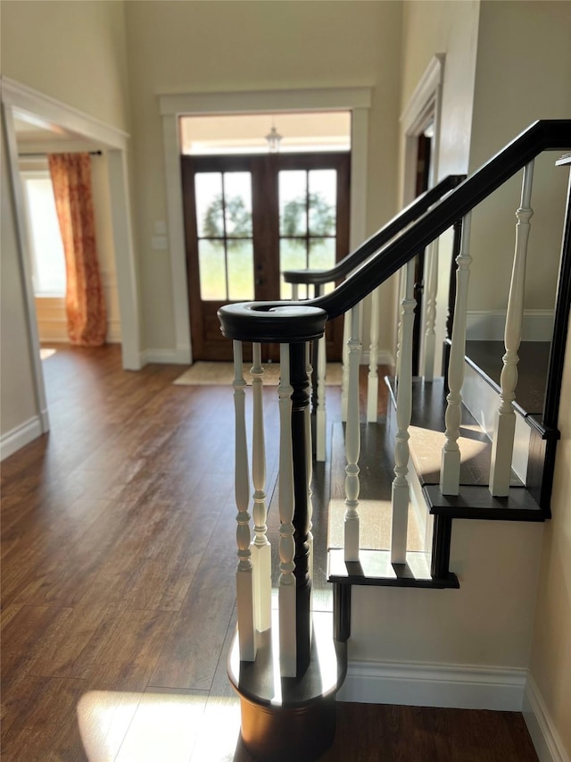 entrance foyer with baseboards, a healthy amount of sunlight, and wood finished floors