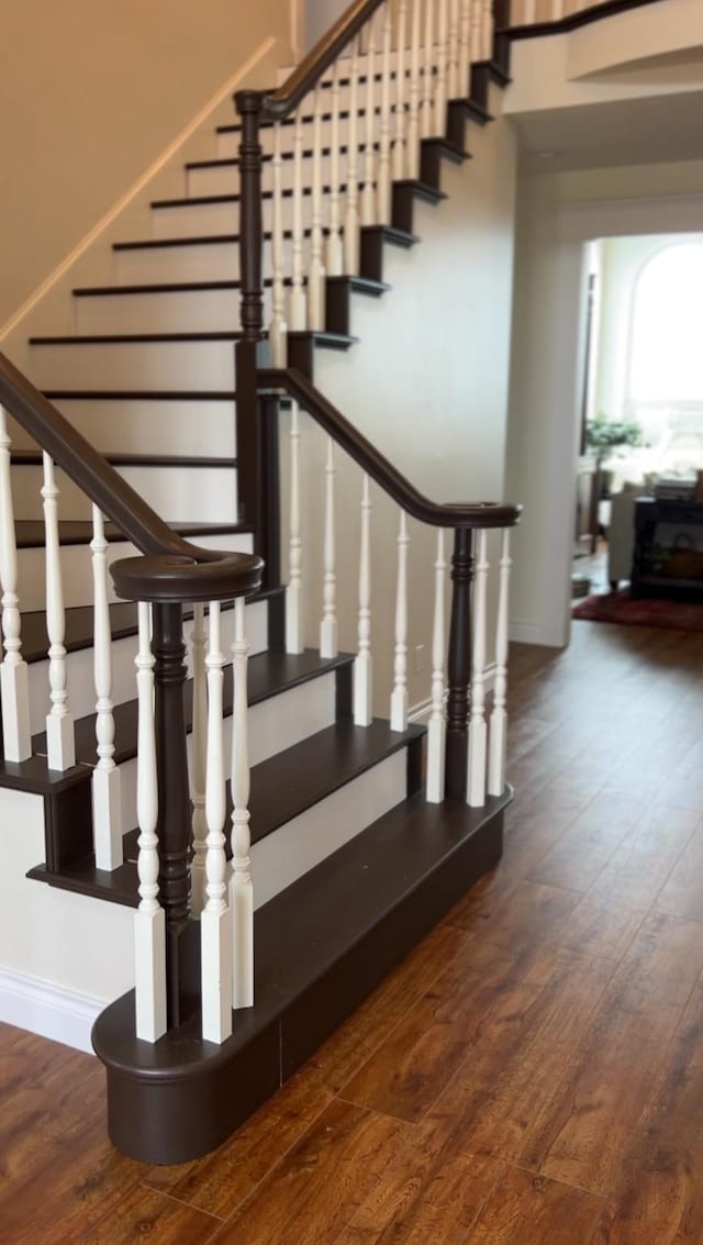staircase featuring wood finished floors and baseboards