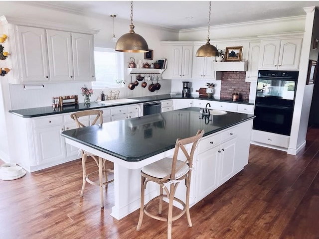 kitchen featuring white cabinets, dark countertops, and black appliances