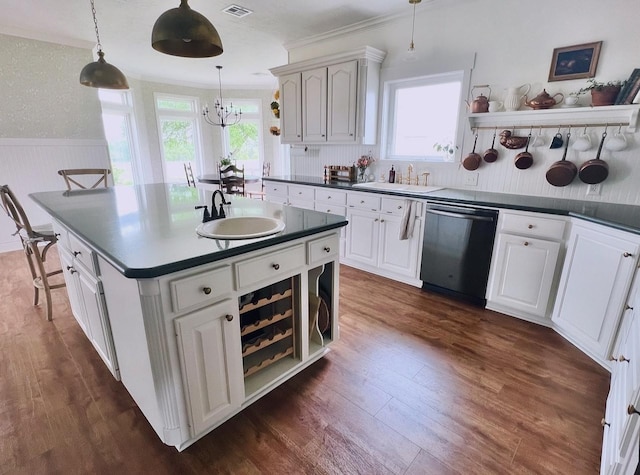 kitchen featuring dark countertops, dishwashing machine, a sink, and dark wood-style floors
