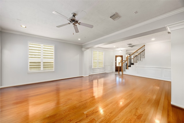 2634 Couch St, Houston, TX 77008 - unfurnished living room featuring light wood-type flooring, visible vents, a ceiling fan, stairs, and ornamental molding