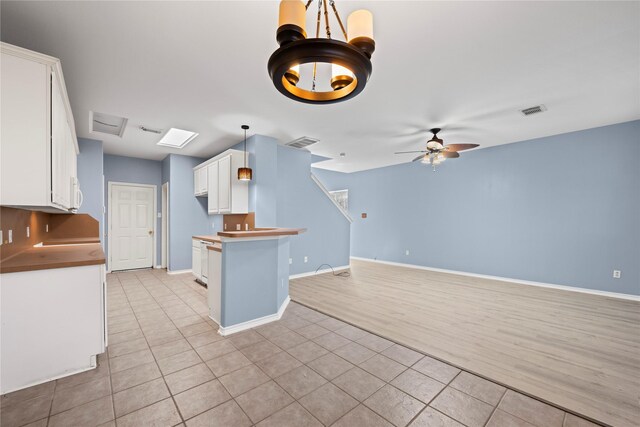 16854 Carrollton Creek Ln, Houston, TX 77084 - kitchen featuring white cabinets, a ceiling fan, visible vents, and light tile patterned flooring