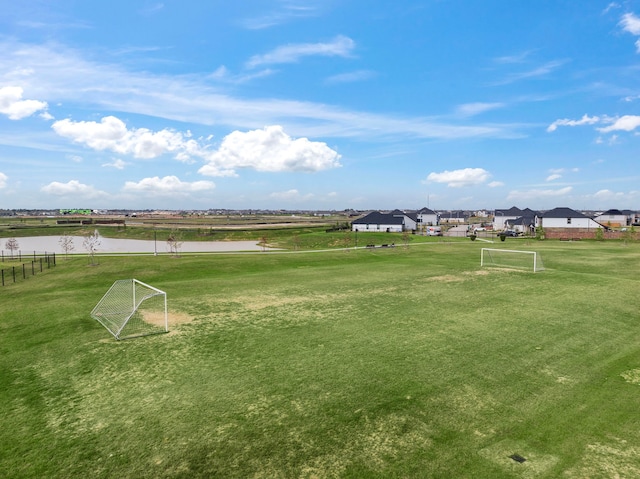 view of property's community featuring a sport area and a water view