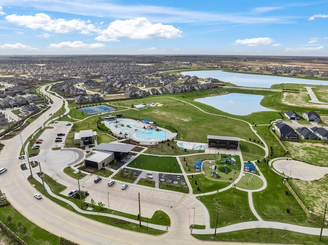 aerial view of property and surrounding area featuring a nearby body of water and nearby suburban area