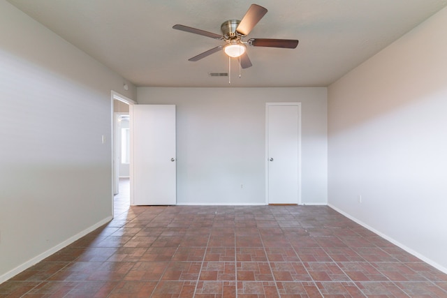 unfurnished room featuring visible vents, baseboards, and ceiling fan