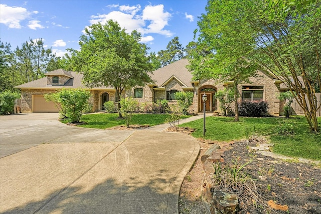 41411 Roundup Rd, Magnolia, TX 77354 - view of front facade with concrete driveway, a front yard, an attached garage, and brick siding