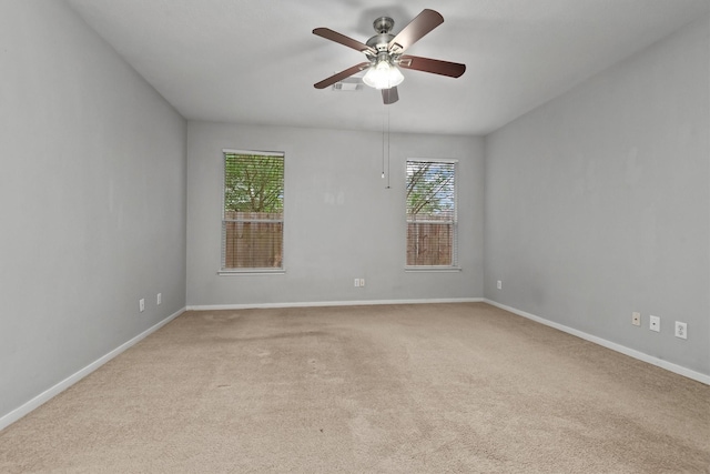 carpeted empty room with a ceiling fan and baseboards