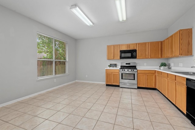 kitchen featuring light countertops, baseboards, a sink, and black appliances