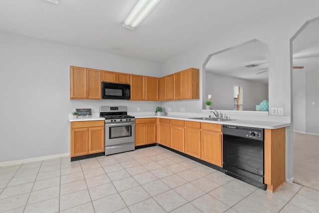 kitchen with a sink, baseboards, black appliances, light countertops, and light tile patterned floors