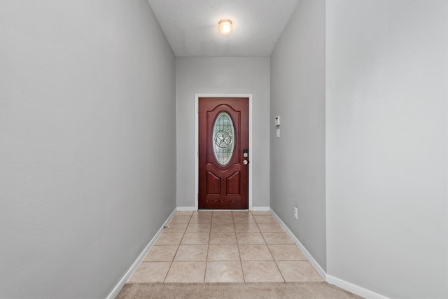 entryway with baseboards and light tile patterned floors