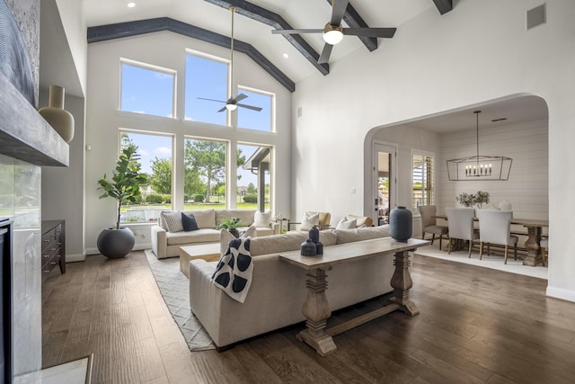 living room featuring arched walkways, ceiling fan with notable chandelier, high vaulted ceiling, and hardwood / wood-style flooring