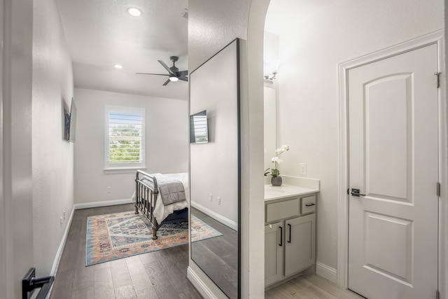 bathroom featuring ceiling fan, vanity, recessed lighting, baseboards, and wood finished floors