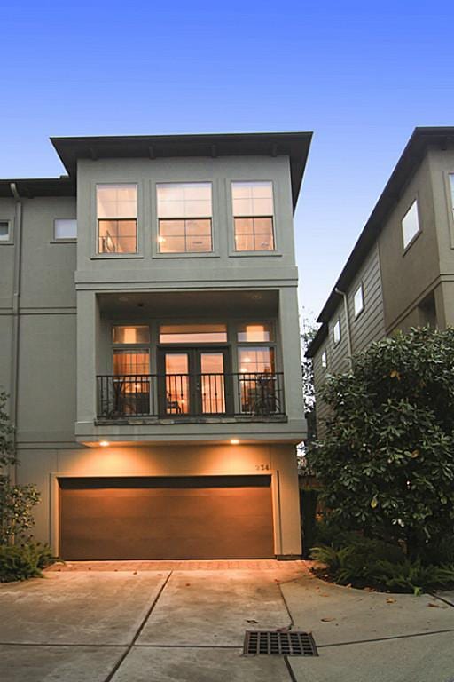 view of front of home with driveway, a balcony, and a garage