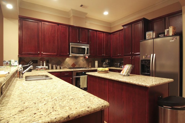 kitchen with light stone counters, a center island, a sink, reddish brown cabinets, and appliances with stainless steel finishes