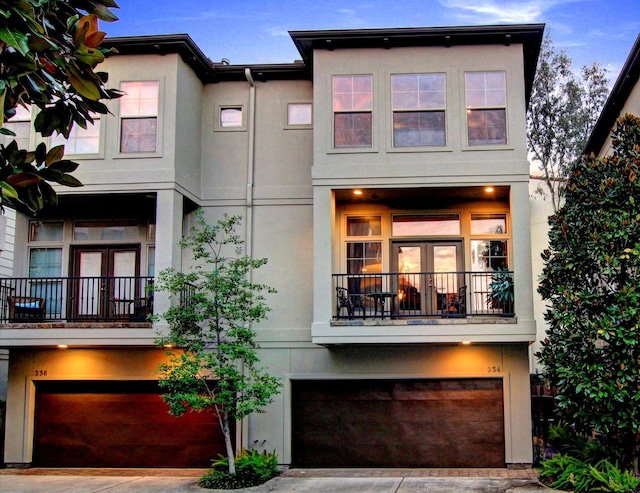 234 Detering St, Houston, TX 77007 - view of front of property with stucco siding, an attached garage, a balcony, and driveway