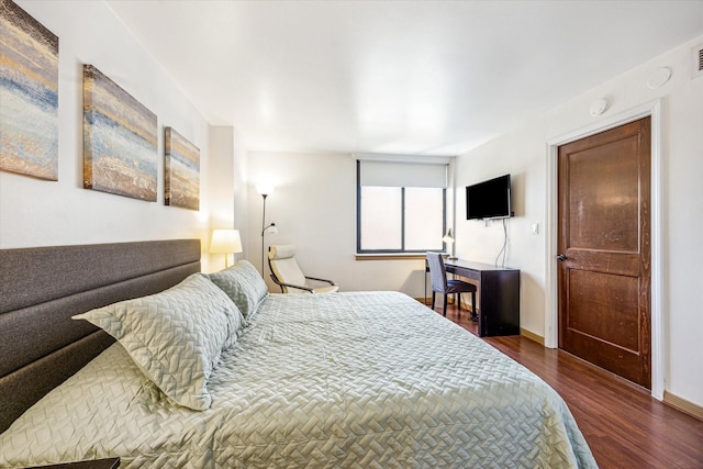 bedroom featuring baseboards and dark wood-type flooring