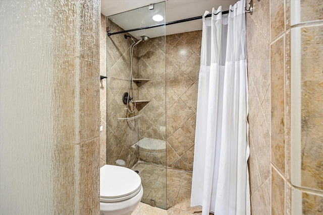 full bath featuring toilet and tiled shower