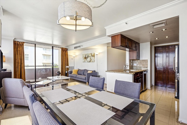 dining space with crown molding, visible vents, and light tile patterned flooring