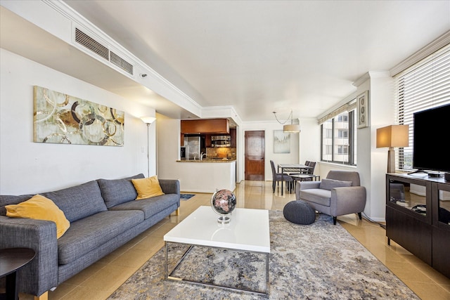 living room featuring light tile patterned flooring, visible vents, and crown molding