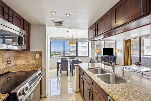 kitchen with a sink, light tile patterned flooring, baseboards, visible vents, and appliances with stainless steel finishes