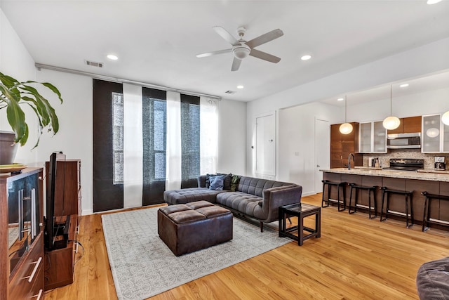 living room featuring recessed lighting, light wood finished floors, ceiling fan, and visible vents