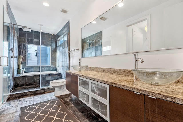 bathroom with visible vents, a shower stall, and a sink