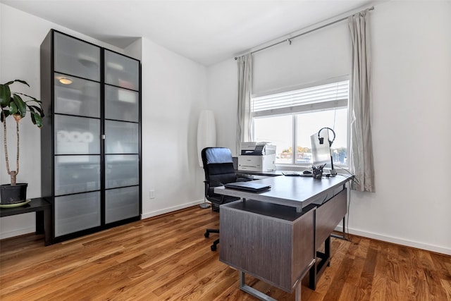 home office featuring baseboards and wood finished floors