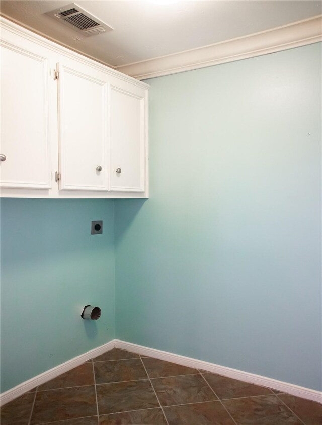 234 Fantasy Ln, Montgomery, TX 77356 - washroom featuring electric dryer hookup, crown molding, dark tile patterned flooring, and cabinet space