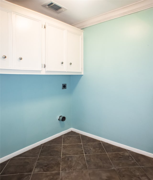 234 Fantasy Ln, Montgomery, TX 77356 - laundry area with cabinet space, hookup for an electric dryer, crown molding, and dark tile patterned floors
