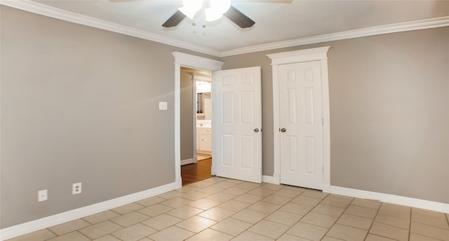 unfurnished bedroom featuring light tile patterned floors, crown molding, baseboards, and a ceiling fan