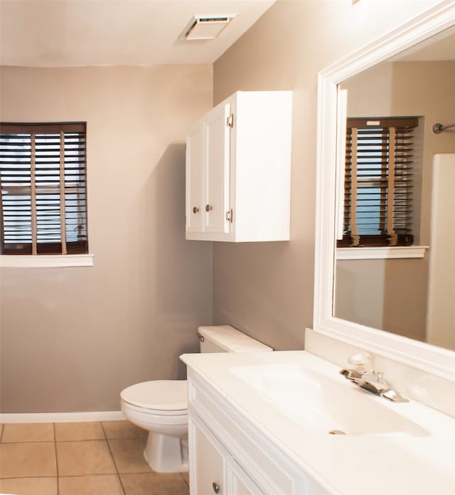 bathroom featuring tile patterned flooring, toilet, vanity, and baseboards