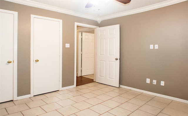 unfurnished bedroom featuring crown molding, baseboards, a ceiling fan, and light tile patterned floors