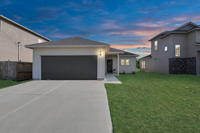 view of front facade featuring a front lawn, fence, a shingled roof, concrete driveway, and an attached garage